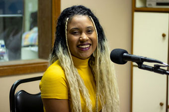 Maya Fernandes no estúdio de áudio para gravação do podcast