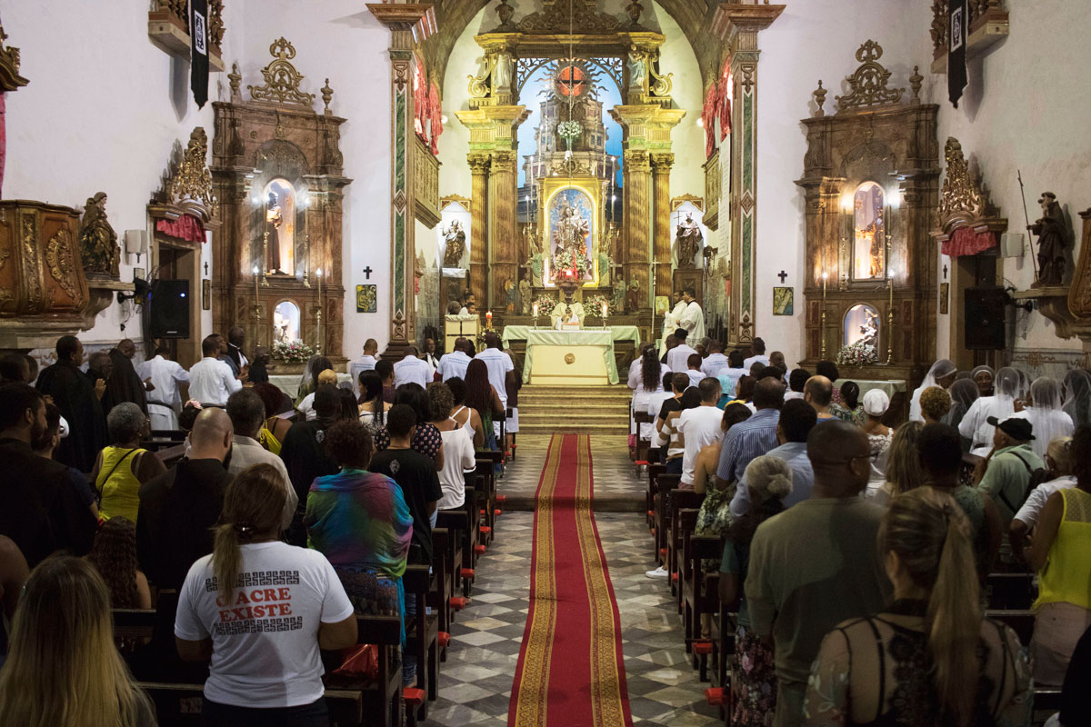 Interior da Igreja do Rosário com fiéis participando da Santa Missa