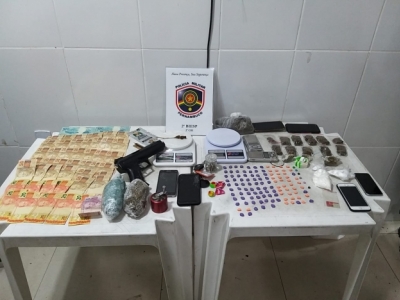 Armas, drogas e dinheiro em cima de mesa 
