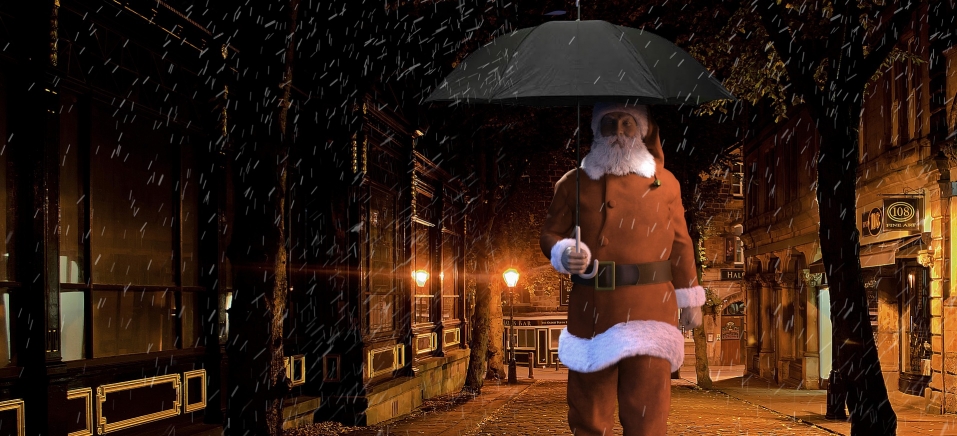 Papai noel segurando guarda-chuva preto 