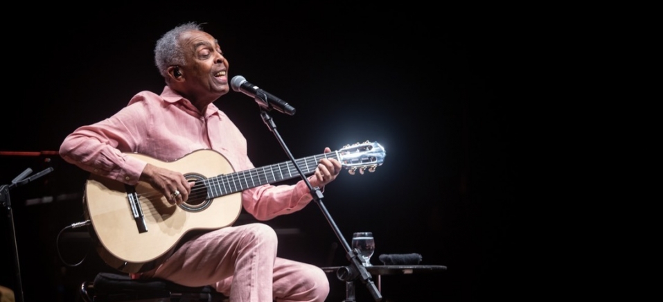 Gilberto Gil tocando violo e cantando em show 