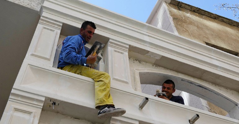 Dois trabalhadores na reforma de um prdio em Tirana, na Albnia